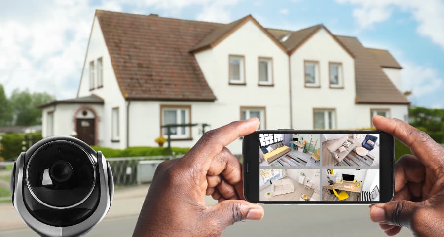 Man holding mobile device and looking at footage from surveillance cameras